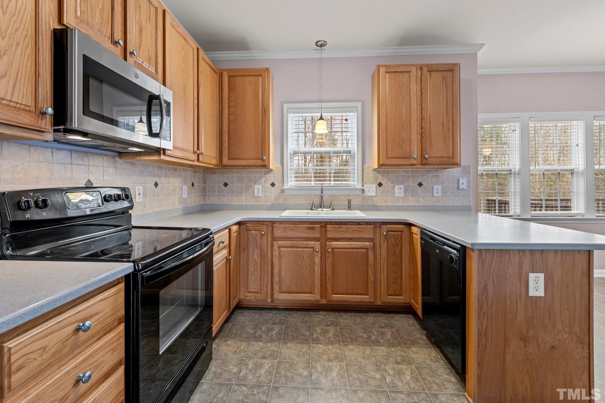 1413 Shady Rise Glen Raleigh, NC 27603 - Photo 24 of 39 a kitchen with stainless steel appliances granite countertop a stove microwave and sink