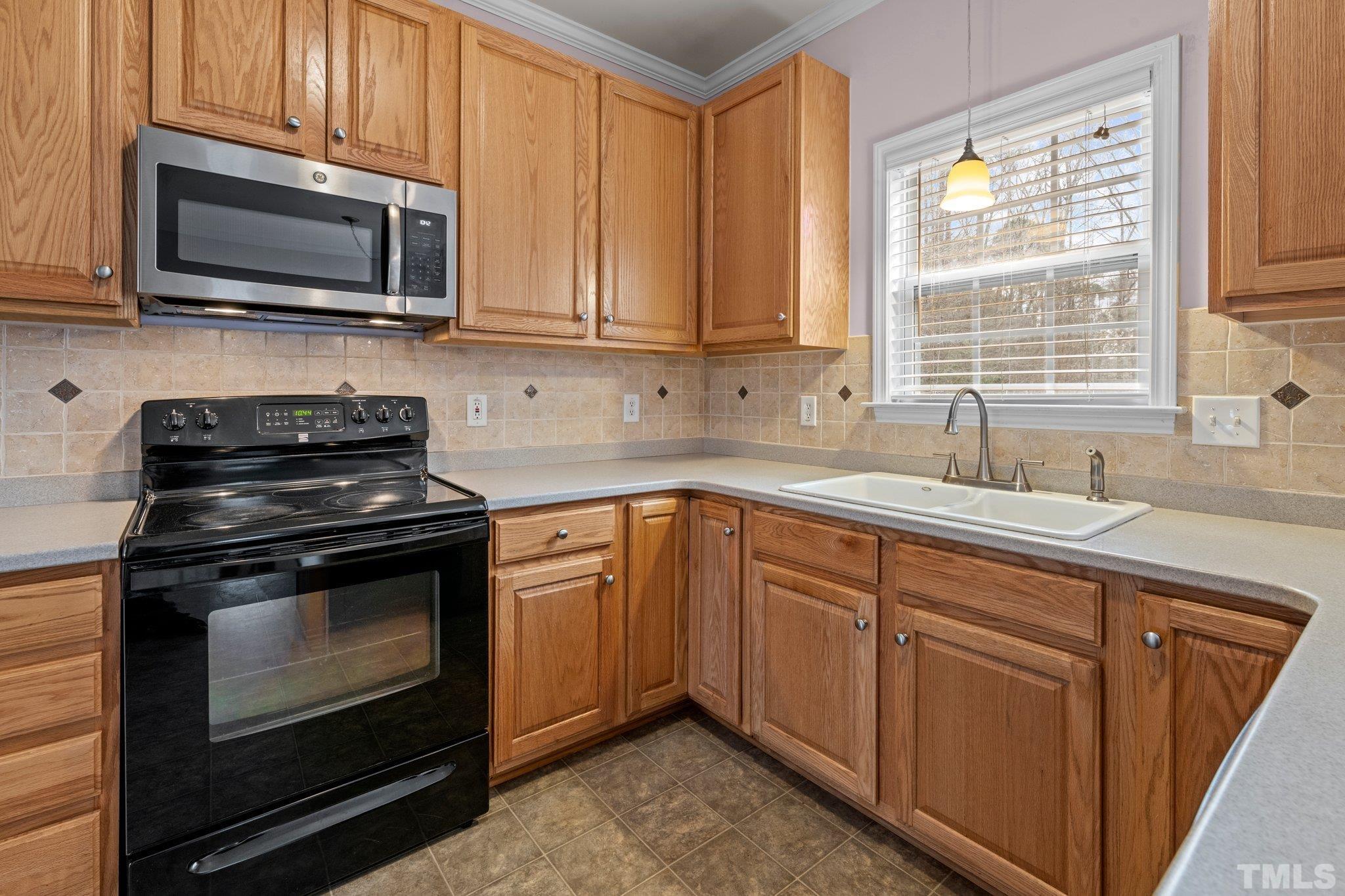 1413 Shady Rise Glen Raleigh, NC 27603 - Photo 25 of 39 a kitchen with granite countertop cabinets stainless steel appliances a window and a sink
