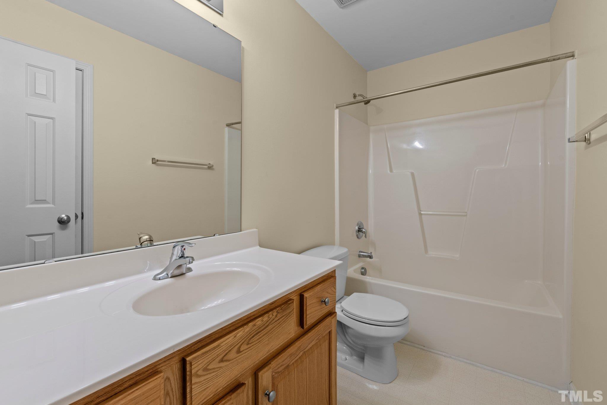 1413 Shady Rise Glen Raleigh, NC 27603 - Photo 31 of 39 a bathroom with a sink a toilet and a large mirror