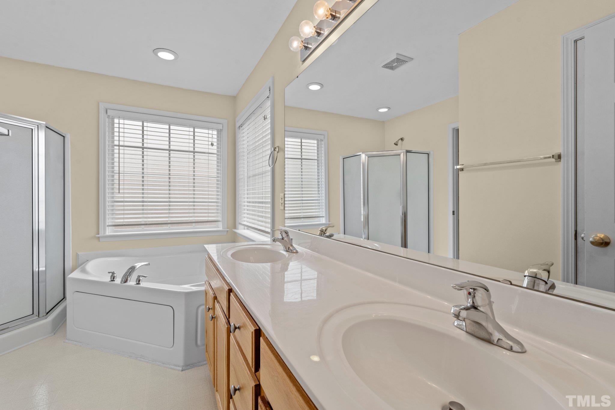 1413 Shady Rise Glen Raleigh, NC 27603 - Photo 34 of 39 a bathroom with a granite countertop tub sink and mirror