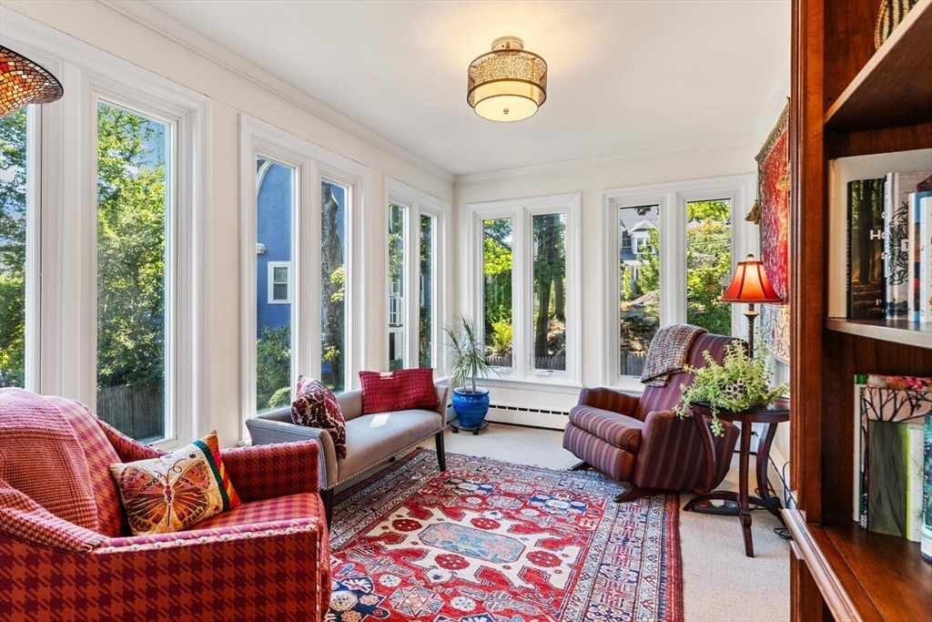 8 Monadnock Road Arlington, MA 02476 - Photo 15 of 37 a living room with furniture a flat screen tv and a floor to ceiling window