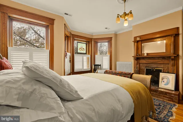 a bedroom with a bed a chair and a chandelier