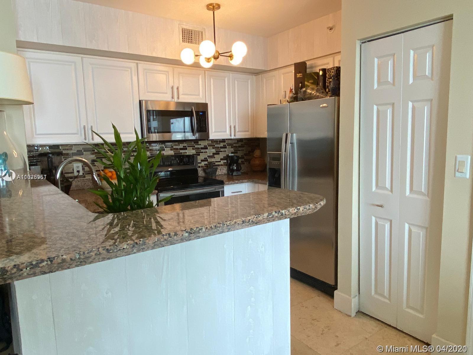 1155 Brickell Bay Drive, Unit 3008 Miami, FL 33131 - Photo 6 of 21 a kitchen with granite countertop a refrigerator a stove a microwave oven with a dining table and chairs