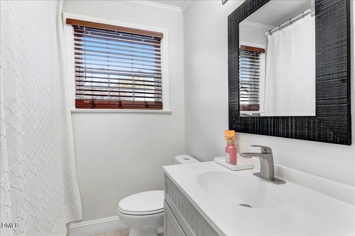 313 South 4th Street Smithfield, NC 27577 - Photo 17 of 31 a bathroom with a sink a toilet and a window