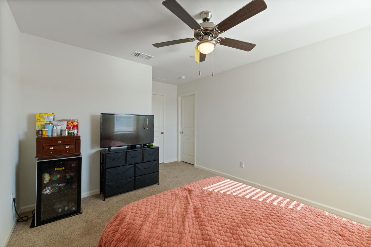 802 Riesling Lane Coalinga, CA 93210 - Photo 24 of 68 a bedroom with a bed and a flat tv screen on dresser
