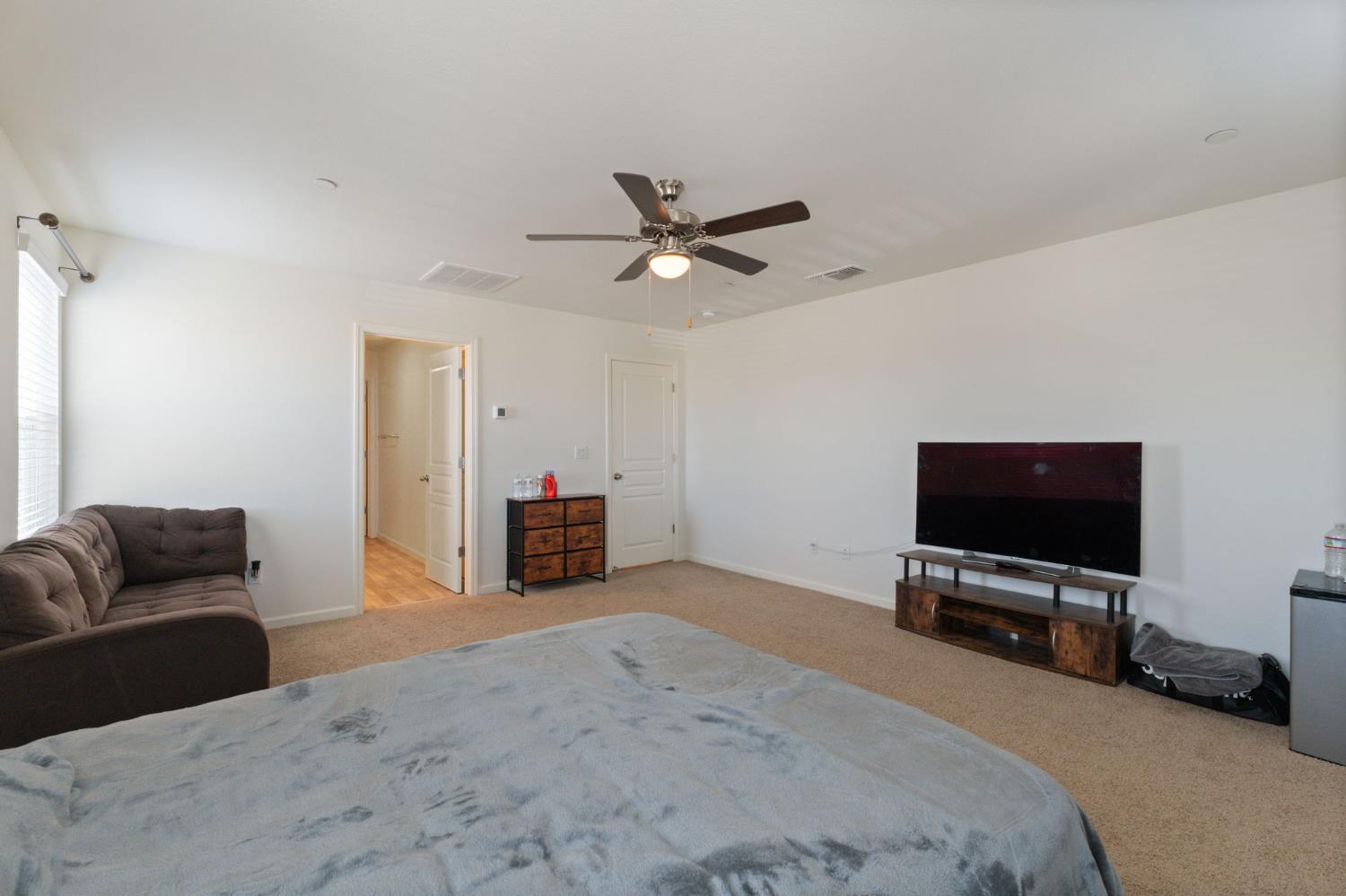 802 Riesling Lane Coalinga, CA 93210 - Photo 35 of 68 a bedroom with furniture and a flat screen tv