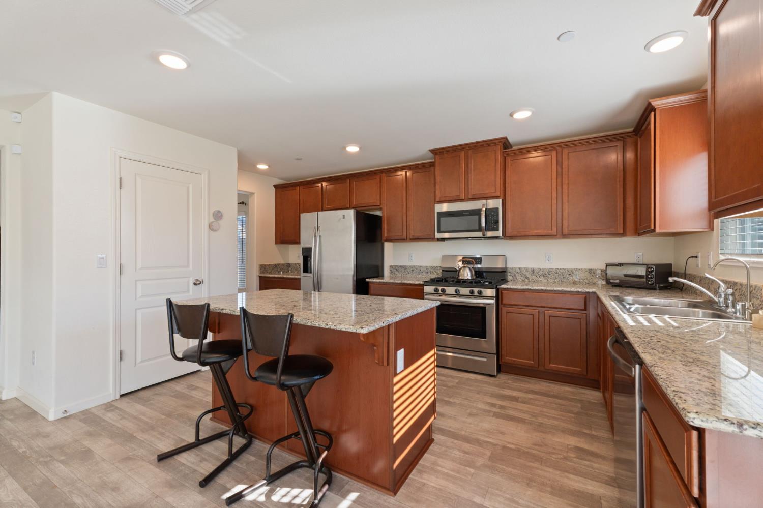 802 Riesling Lane Coalinga, CA 93210 - Photo 5 of 68 a kitchen with a stove a sink and a refrigerator