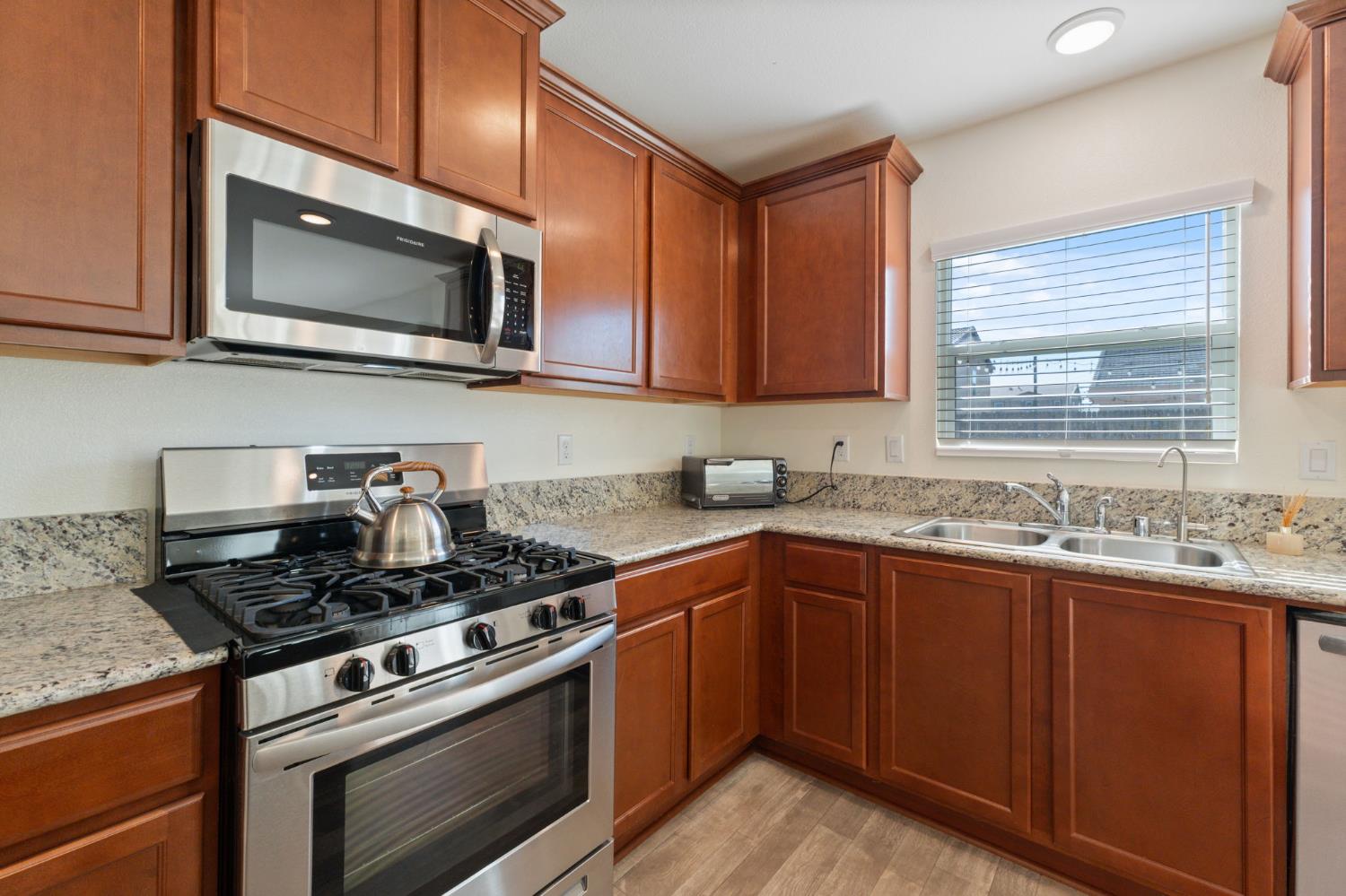 802 Riesling Lane Coalinga, CA 93210 - Photo 8 of 68 a kitchen with stainless steel appliances granite countertop a sink stove and microwave