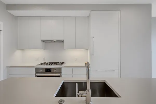 a kitchen with a sink a stove and cabinets