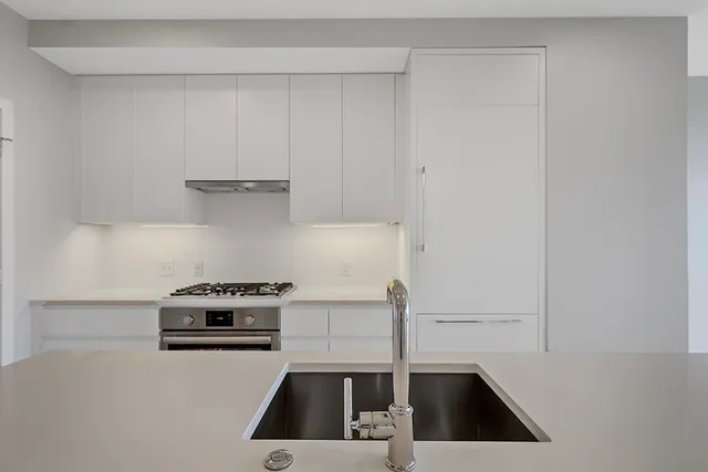a kitchen with a sink a stove and cabinets