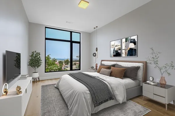 a bedroom with a large bed and a flat tv screen on dresser
