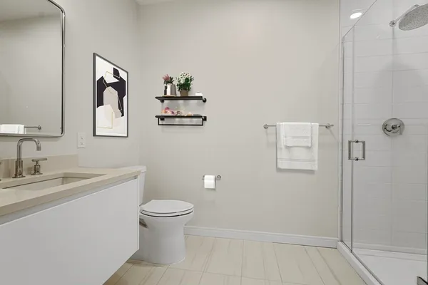 a bathroom with a toilet sink vanity and mirror