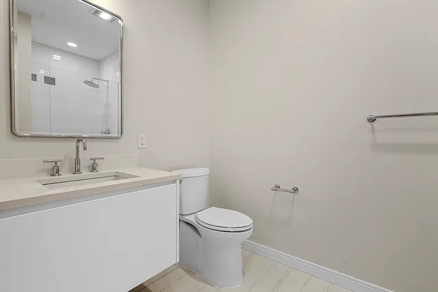 a bathroom with a toilet a sink and mirror