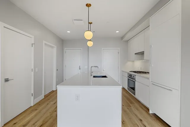 a kitchen with stove cabinets and wooden floor