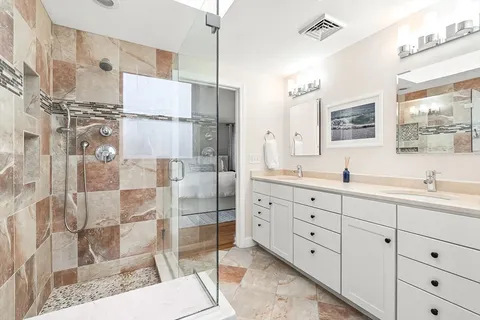 a spacious bathroom with double vanity and a shower