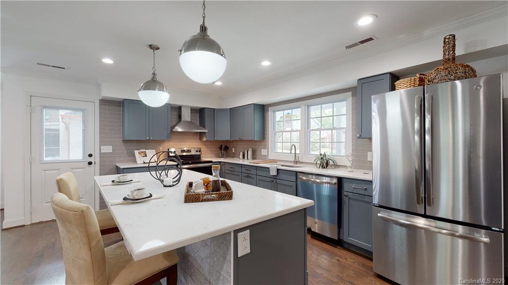 a kitchen with refrigerator cabinets dining table and chairs