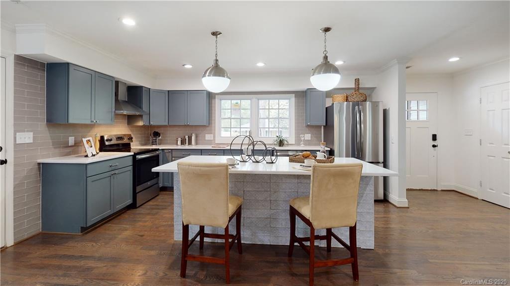 244 Scofield Road Charlotte, NC 28209 - Photo 6 of 30 a kitchen with a dining table chairs refrigerator and microwave