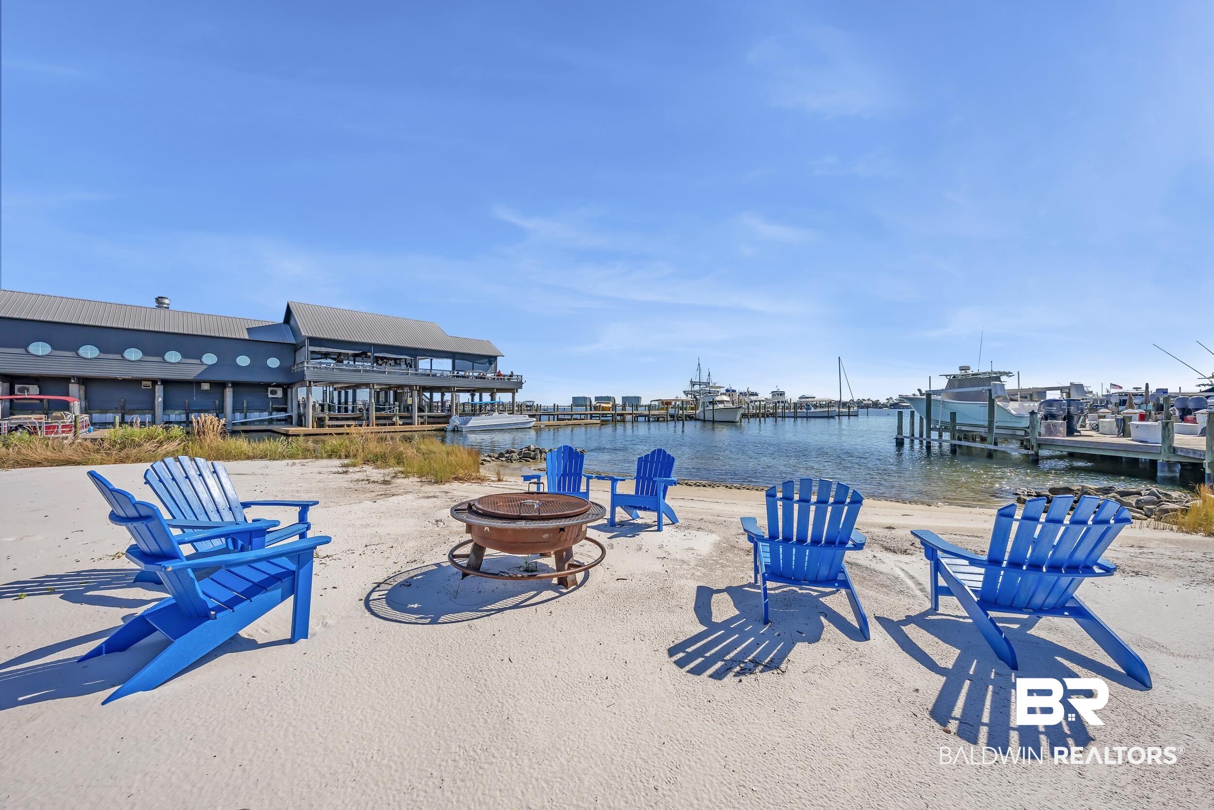 27282 Canal Road, Unit 104 Orange Beach, AL 36561 - Photo 56 of 79 View of patio featuring a water view, a fire pit, and a boat dock