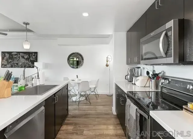 a kitchen with a sink a microwave and cabinets