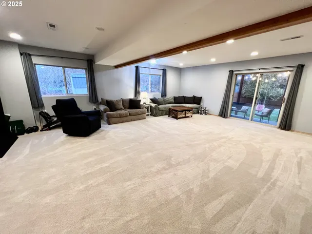 a large bedroom with a bed a couch and a large window