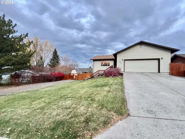a front view of house with yard and trees in the background