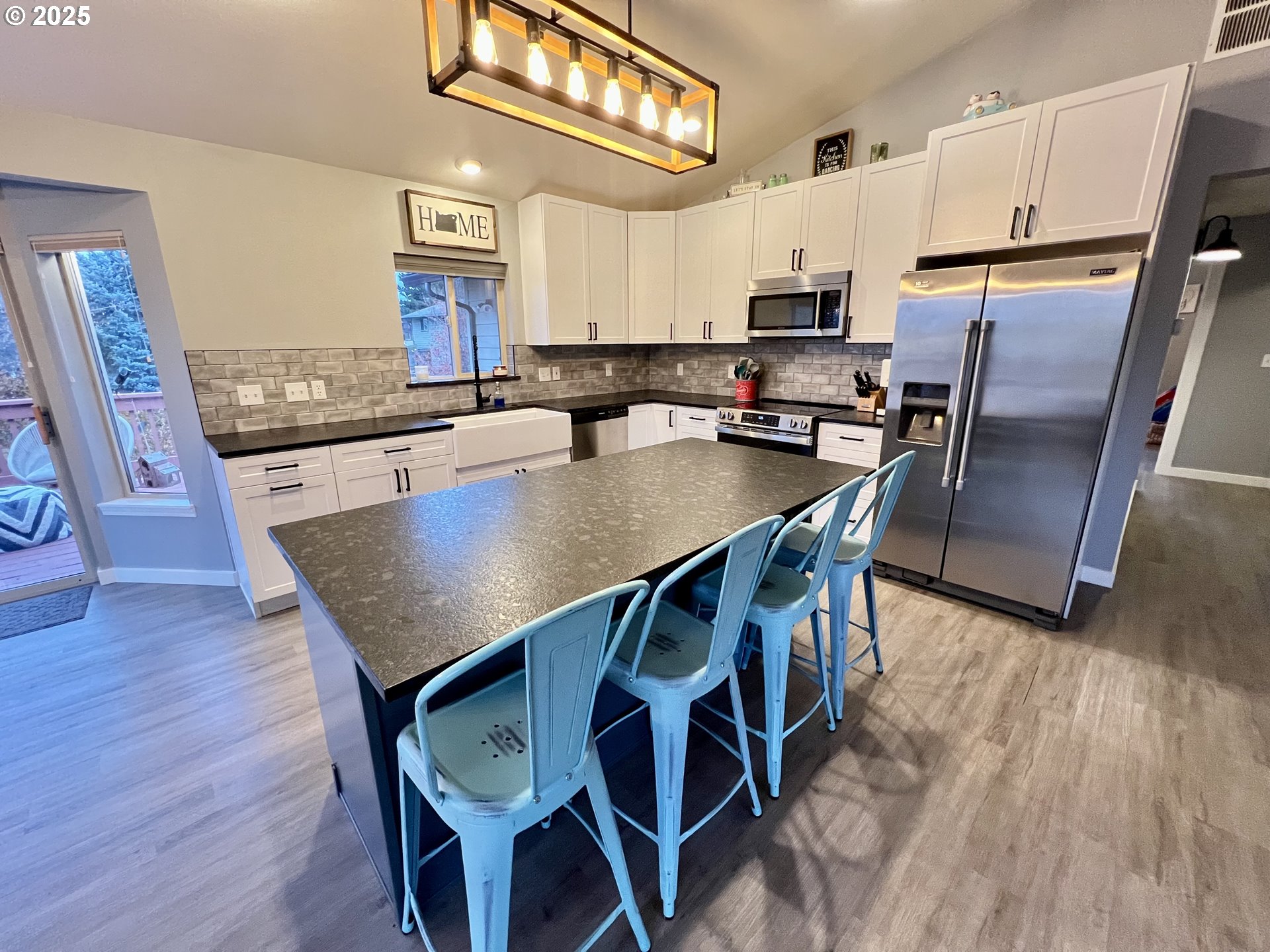 707 Highland Drive La Grande, OR 97850 - Photo 5 of 28 a kitchen with granite countertop stainless steel appliances a table chairs microwave and refrigerator