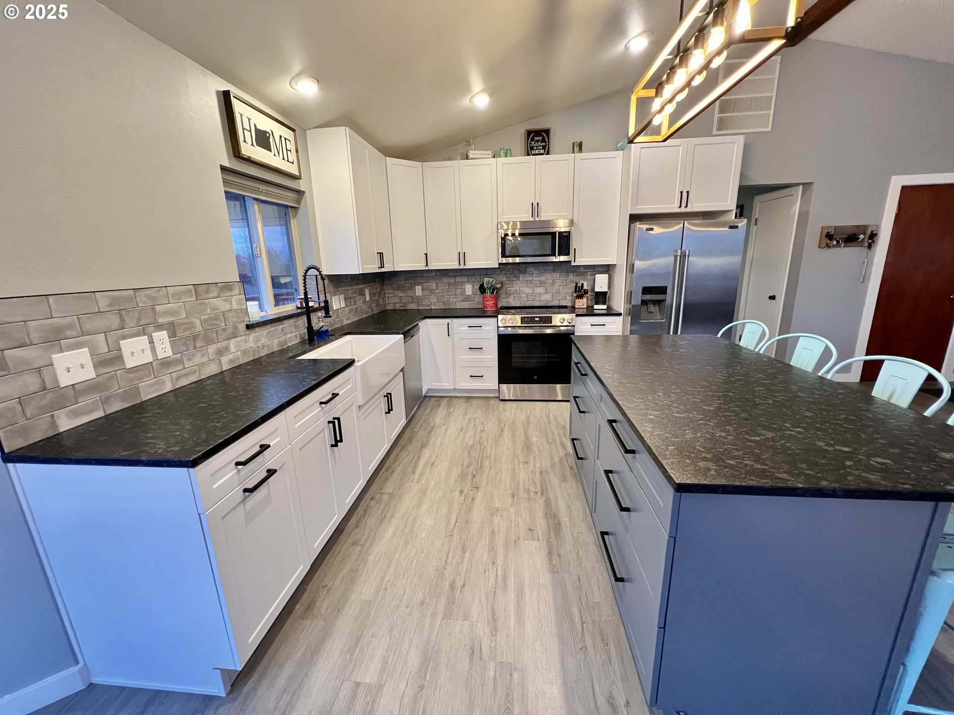 707 Highland Drive La Grande, OR 97850 - Photo 6 of 28 a large kitchen with stainless steel appliances granite countertop a lot of counter space and wooden floors