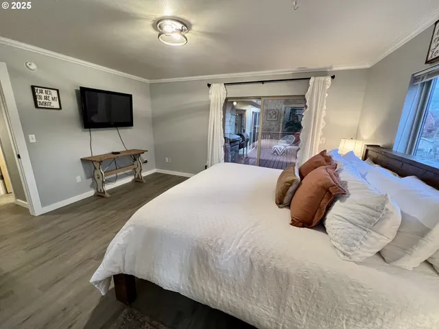 a bedroom with a bed and a flat tv screen on dresser