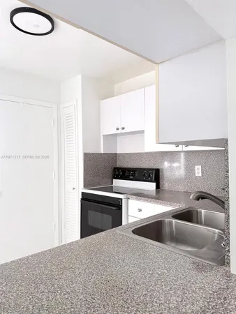 a kitchen with a sink cabinets and a window