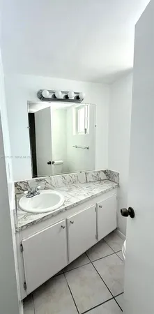 a bathroom with a granite countertop sink and a mirror