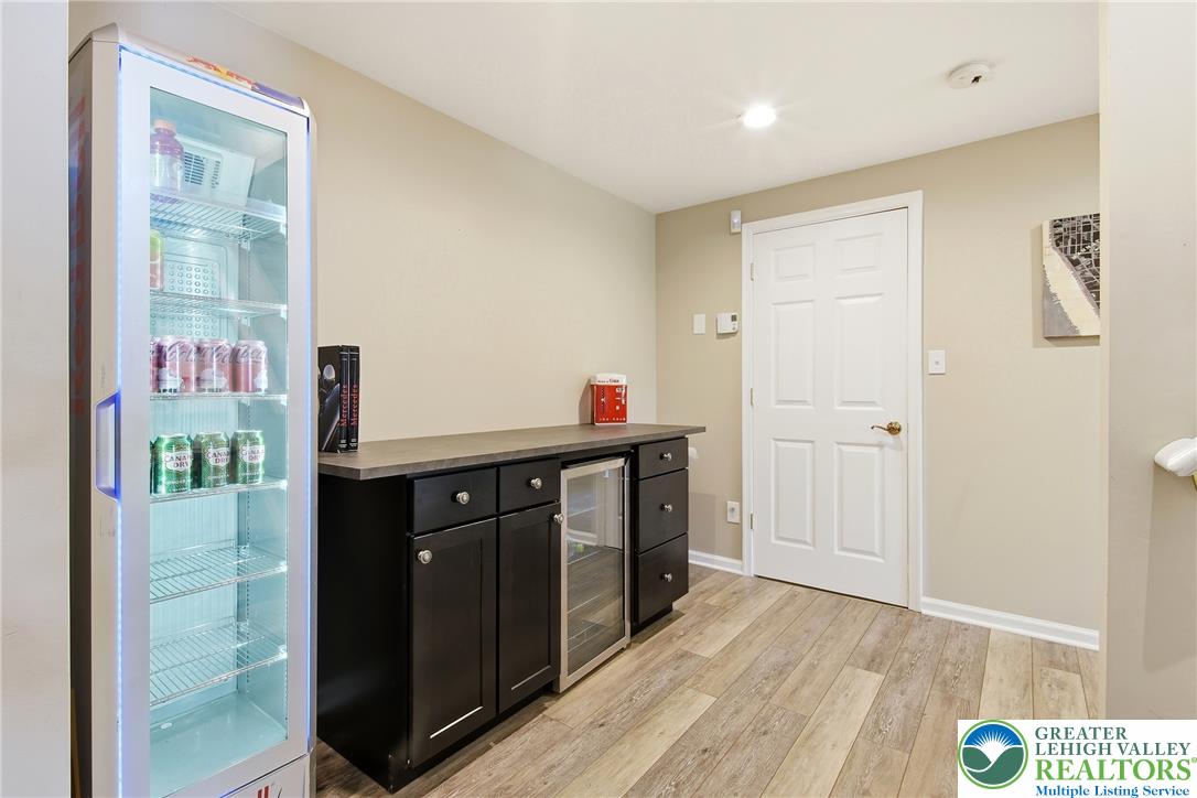 115 West Butternut Road Hellertown, PA 18055 - Photo 52 of 97 A well-appointed wet bar area, featuring a beverage refrigerator and wood-look flooring.