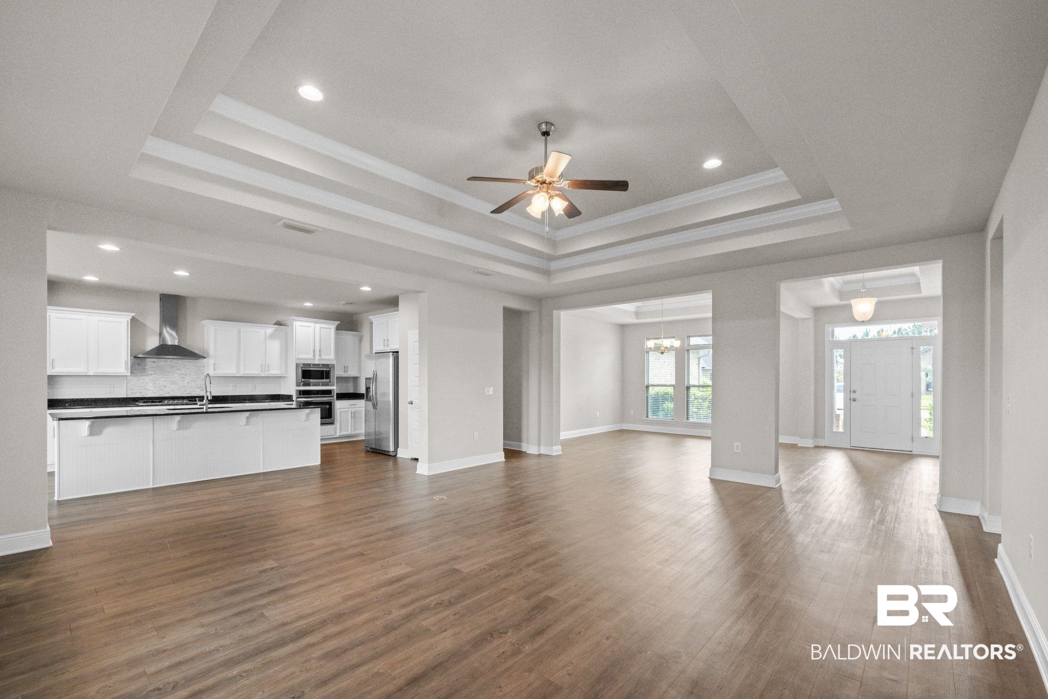 2074 Bourbon Street Foley, AL 36535 - Photo 15 of 46 Unfurnished living room featuring ceiling fan, hardwood / wood-style floors, a raised ceiling, sink, and ornamental molding