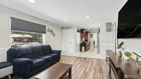 a living room with furniture a wooden floor and a flat screen tv