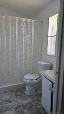a white toilet sitting next to a shower curtain