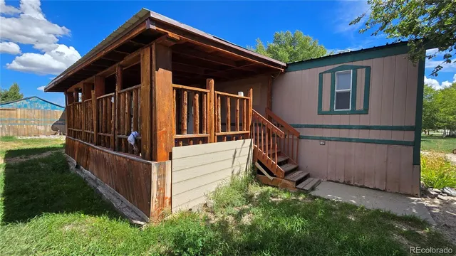 a view of wooden house with a small yard