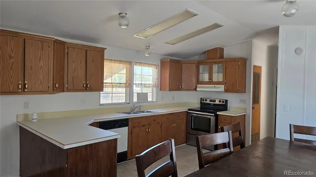 a kitchen with a sink a stove and cabinets