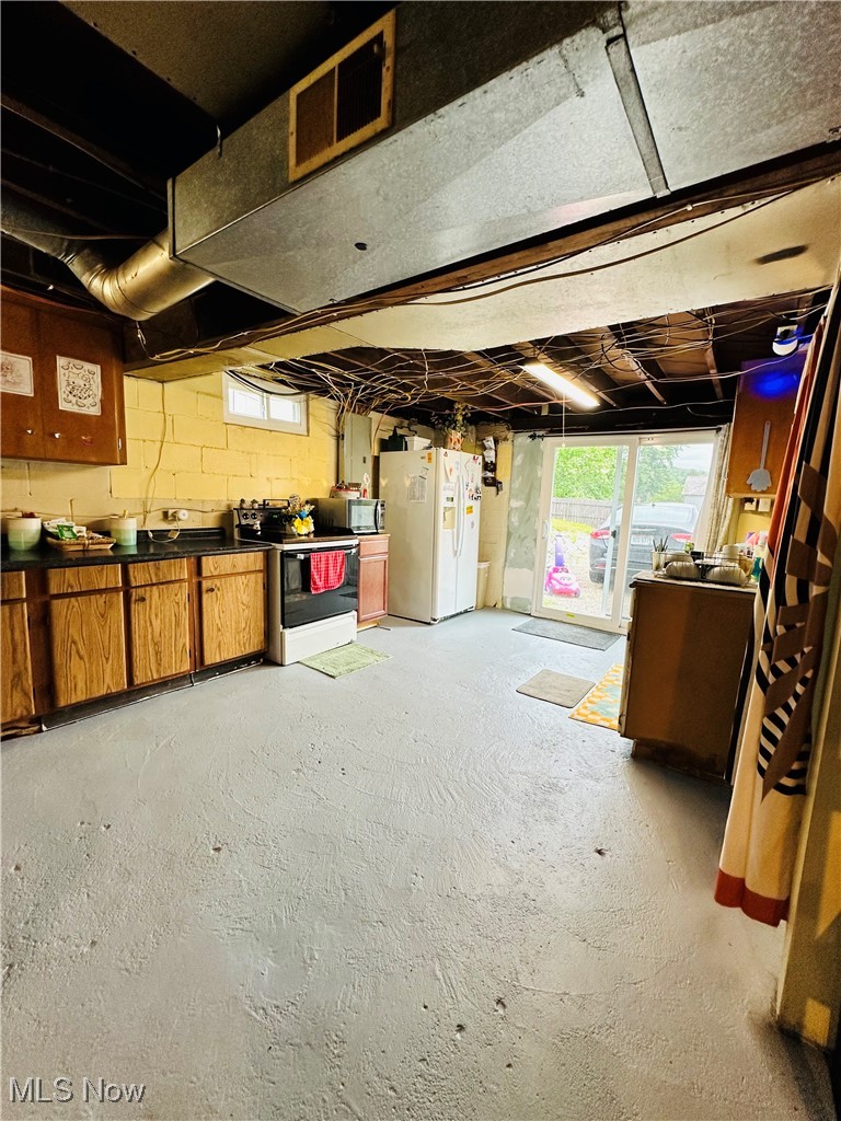 418 Main Street Philo, OH 43771 - Photo 22 of 37 Below grade area with white refrigerator with ice dispenser and concrete block wall