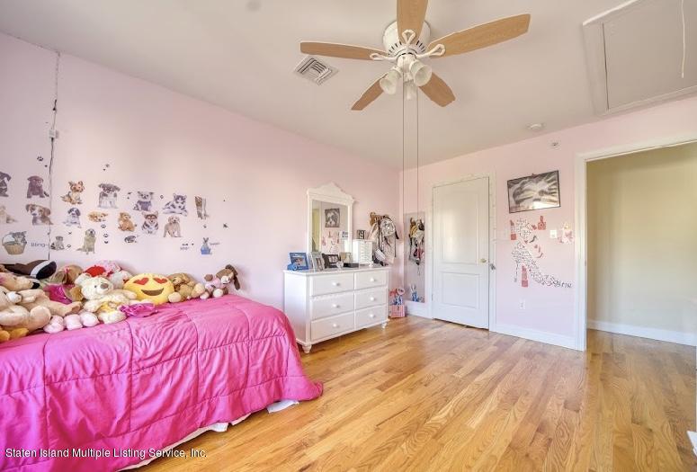 47 Brookside Loop Staten Island, NY 10309 - Photo 13 of 26 a bedroom with a bed and a chandelier