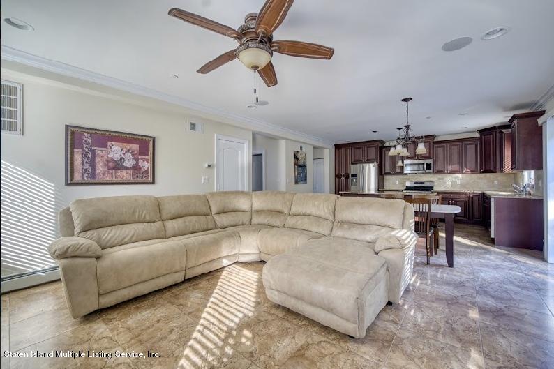 47 Brookside Loop Staten Island, NY 10309 - Photo 9 of 26 a living room with furniture kitchen view and a chandelier