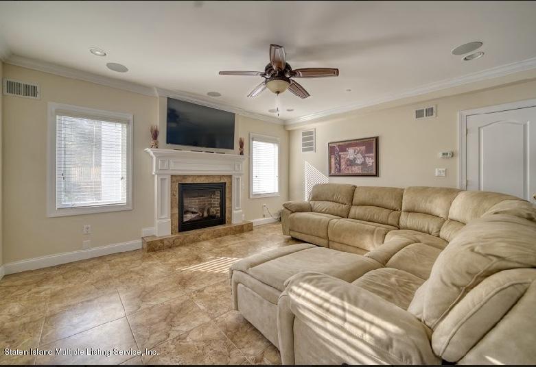47 Brookside Loop Staten Island, NY 10309 - Photo 10 of 26 a living room with a flat screen tv and a fireplace