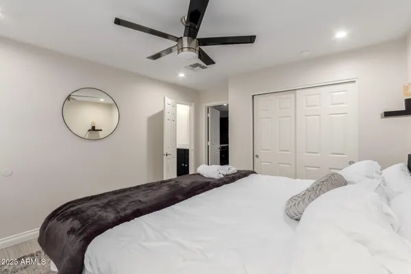 a bedroom with a large bed and a chandelier