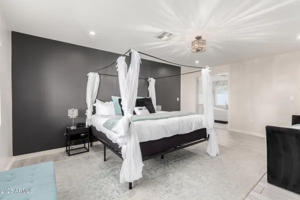 a bed sitting in a room next to a lamp