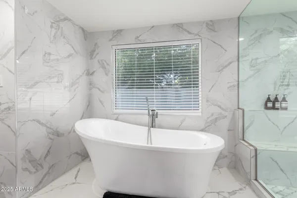 a white bath tub sitting in a bathroom next to a white door