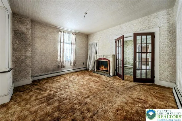 a view of an empty room with window and fireplace