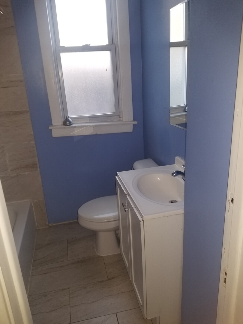 2453 West 46th Place, Unit 1 Chicago, IL 60632 - Photo 10 of 13 a bathroom with a sink a toilet and a vanity