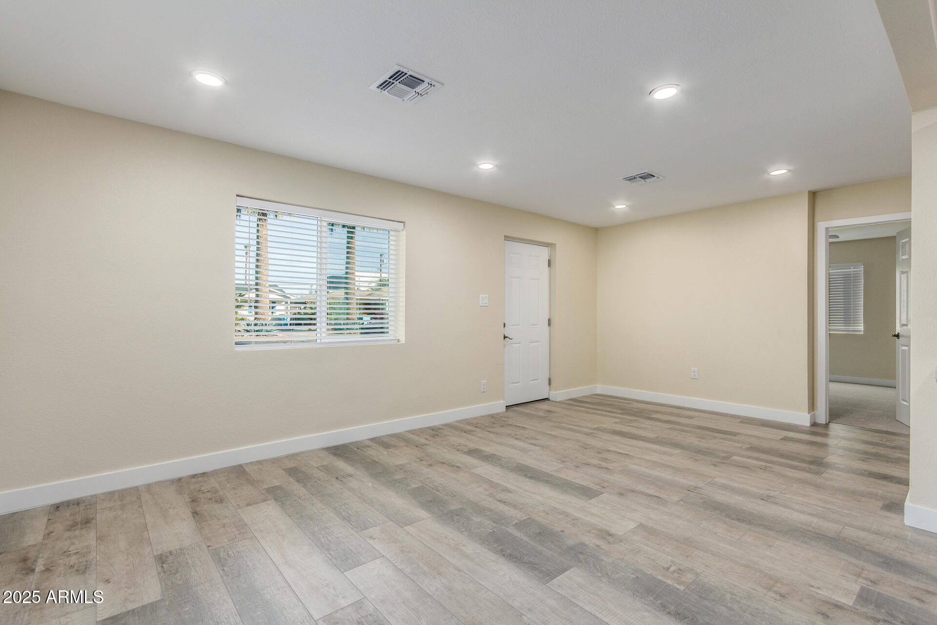 2749 West Montecito Avenue Phoenix, AZ 85017 - Photo 5 of 20 an empty room with wooden floor and windows