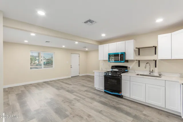a kitchen with a sink a stove and cabinets