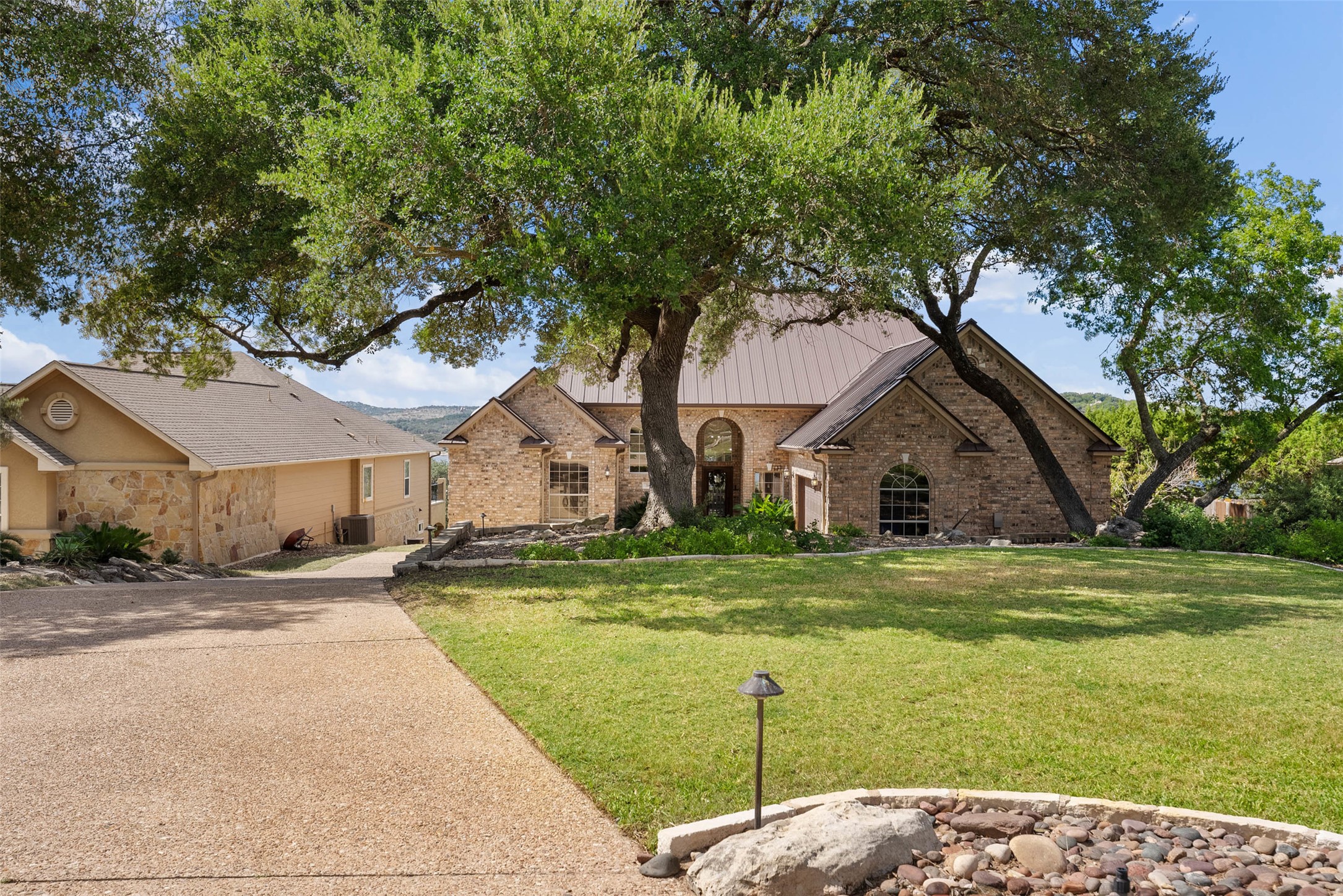 316 Lakefront Drive Point Venture, TX 78645 - Photo 26 of 40 a front view of a house with a garden and trees