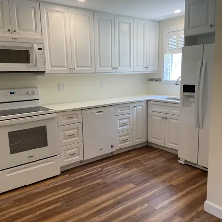 a kitchen with granite countertop white cabinets stainless steel appliances and sink