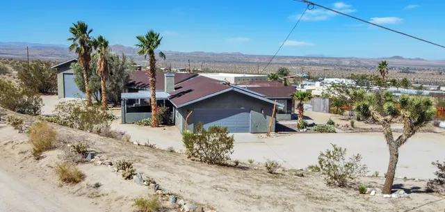 a view of a house with a snow yard and mountain view